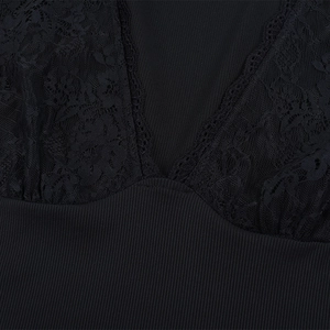 Dettaglio dello scollo a V con pizzo nero delicato e trama in maglia a costine sottili