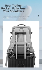 Grey travel backpack detail featuring back trolley sleeve secured on a black suitcase handle