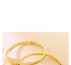 Détail d'un bracelet jonc doré minimaliste avec fermoir à cliquet et finition polie