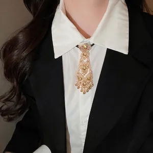 Baroque style gold bolo tie with crystal inlay and tassel on a black and white outfit