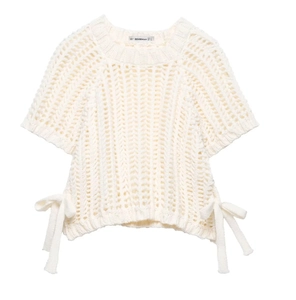Detailed view of white hollow knit top featuring side bow ties and intricate textures