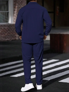 Outdoor back view of men's navy blue two-piece casual jacket and trousers set