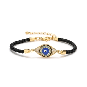 Adjustable evil eye charm bracelet with gold plating, blue enamel and black woven rope