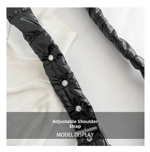 Close-up of adjustable quilted shoulder strap with silver eyelets for a puffer bag