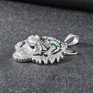 Detailed close-up of a silver tiger head pendant with white diamonds and green eyes