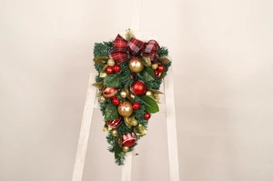 Detailed view of Christmas teardrop swag with red plaid bow and festive gold and red baubles