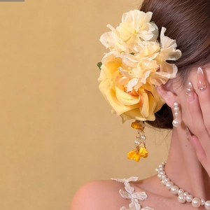 Detail of yellow fabric rose hair clip with organza petals and tassel pearls