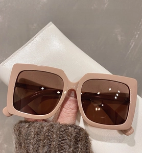Detail view of oversized square beige sunglasses with premium brown tinted lenses