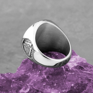 Vintage stainless steel Viking Valknut ring displayed on a purple crystal stone