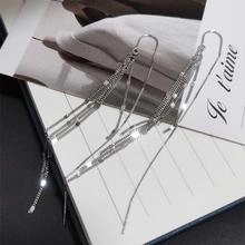 Détail des boucles d'oreilles longues à pampilles en argent S925 avec perle sur papier