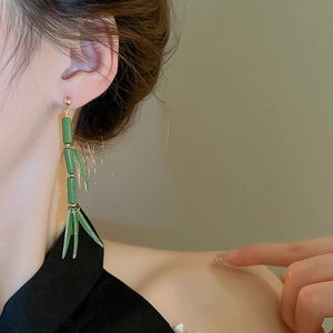 Detail of green bamboo resin earrings worn by model for traditional Chinese style