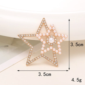 Detail of a star-shaped gold brooch with pearls and rhinestones showing 3.5cm dimensions