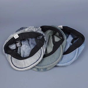 Flat lay detail of vintage washed denim berets in dark blue, medium blue, and grey