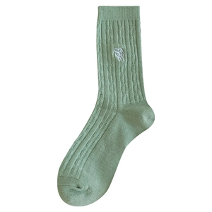 Chaussettes vert sauge en maille torsadée avec broderie sur fond blanc
