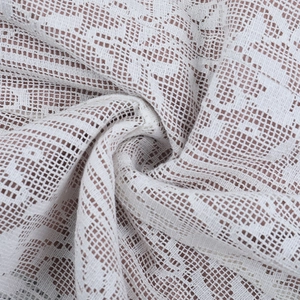 Gros plan sur un tissu en dentelle blanche avec motifs au crochet et texture résille