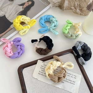 Set of colorful braided elastic hair ties for high ponytails on a white aesthetic background