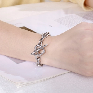 Detail view of silver metal double-layer bracelet with T-bar toggle clasp on wrist