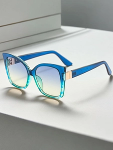 Detail of blue gradient cat-eye sunglasses frame with gold hardware and etched textures