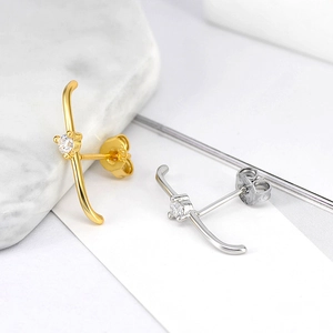 Macro detail of S925 silver cross stud earrings with sparkling round zircon in gold and silver