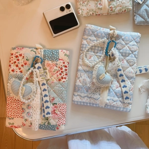Detail of blue floral quilted cotton pouch with zipper and pearl heart charm