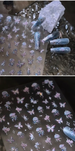 Detail showing iridescent 3D butterfly and jellyfish nail stickers on blue gradient nails
