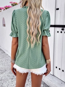 Detail of green eyelet embroidery top showing short puff sleeves and back tie closure