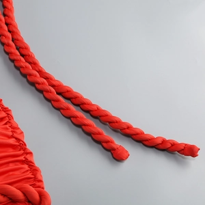Detailed close-up of red braided rope trim and textured knit fabric on party dress