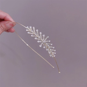 Close-up of golden metal headband featuring leaf-shaped crystal and rhinestone details