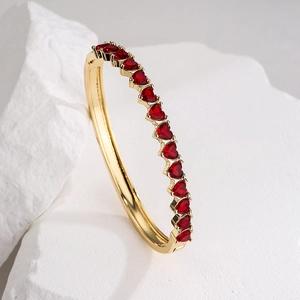 Elegant 18K gold plated bangle featuring heart-shaped red zircons on a white stone base