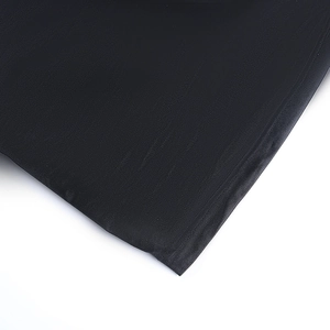 Détail de la robe en dentelle noire montrant la texture du tricot et les finitions soignées