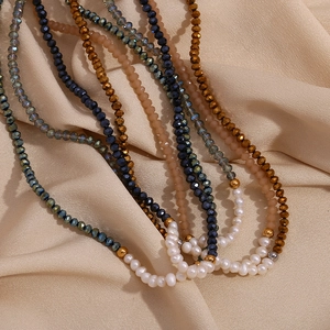 Handmade necklace with white freshwater pearls and blue faceted crystals on beige satin
