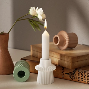 Detail showing matte texture and pleated wave geometry of ceramic candle holders