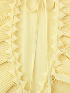 Detail view of light yellow pleated chiffon fabric with serrated edges and lace-up ties