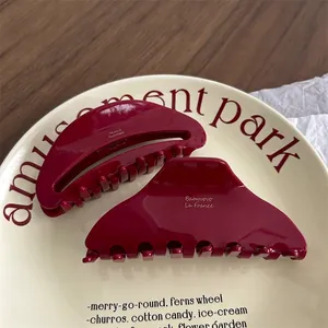 Elegant burgundy acetate hair claws for women in a vintage cream ceramic tray