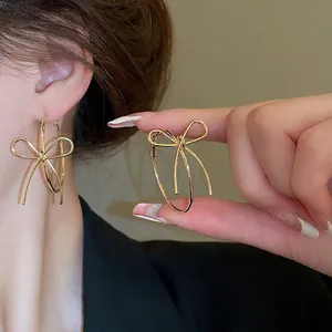 Elegant gold bow-shaped hoop earrings for women featuring a minimalist knot design