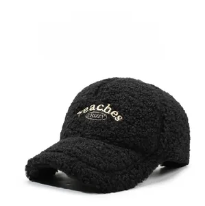 Detailed view of black lamb wool fabric and beige embroidered letters on a baseball cap