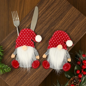 Macro detail of gnome cutlery holder on wood with festive pine and berry decorations