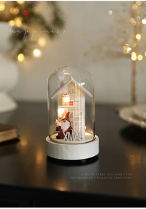 Close-up of glass dome Christmas light with warm LED glowing on a wooden base decor