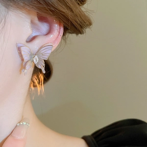 Detailed view of butterfly stud earring featuring lavender wings and golden frame details