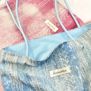 Detail of tie-dye tote bag showing white lace embroidery and fabric texture