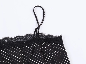 Detail of black polka dot camisole featuring delicate black lace trim and textured fabric