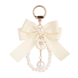 Elegant cream satin bow keychain with pearl ring and gold-plated alloy pendant charm
