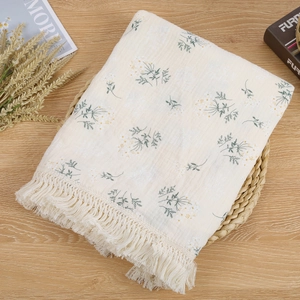 Detail of baby fringe blanket with floral pattern on natural cotton gauze fabric