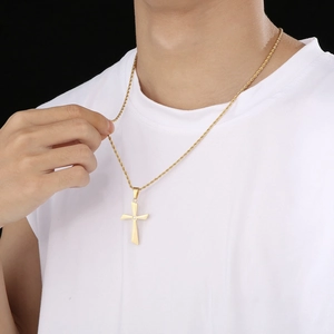 Detailed view of polished gold cross necklace with rope chain on model silhouette