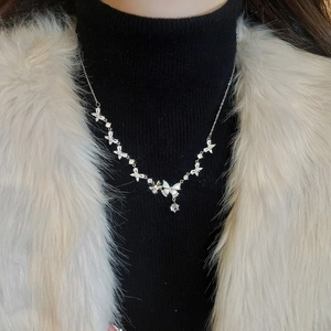 Detailed view of silver butterfly necklace with sparkling zircon pendant on model