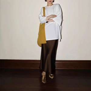 Detail of white cotton batwing sleeve t-shirt paired with a brown satin skirt