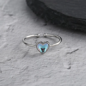 Minimalist silver open heart ring with aurora blue gemstone on textured stone