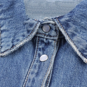 Detail of blue denim dress collar and silver buttons with contrast stitching