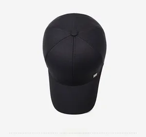 Top view of a black baseball cap with six-panel design and a square silver metal plate