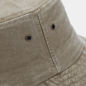 Detail of washed cotton bucket hat showing metal eyelets and reinforced stitching